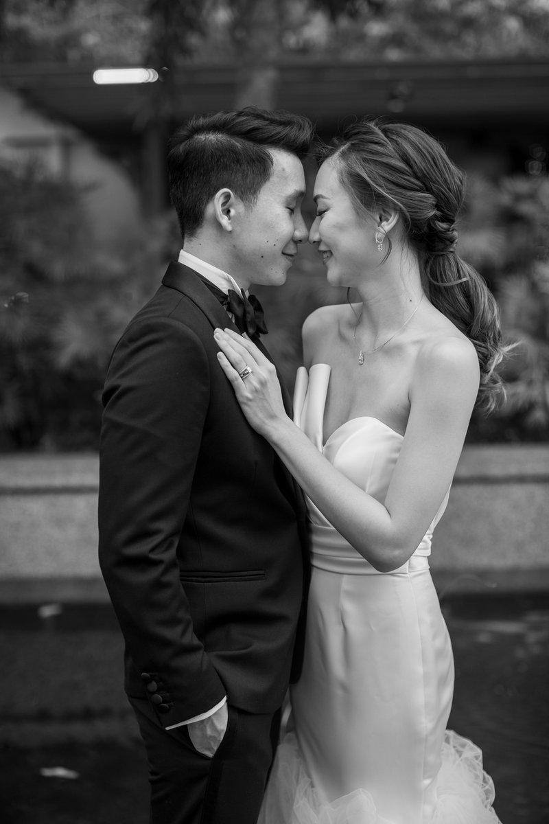 Black-and-white wedding portrait of a couple standing face to face